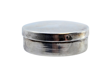  Caixa de comprimidos em prata lisa de forma circular com tampa amovível.